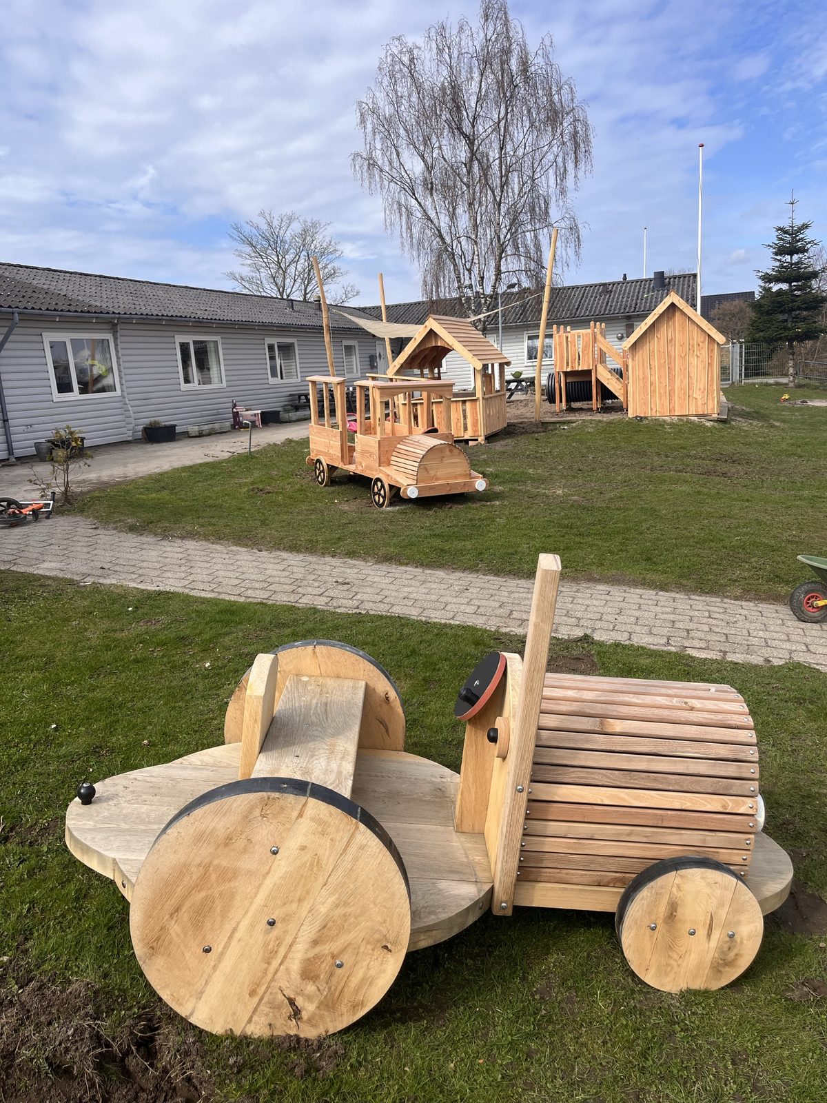 Traktor i massiv kerneegetræ på legepladsen hos Mælkebøtten